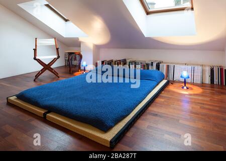 Interno, bel soppalco, letto con copriletto blu Foto Stock