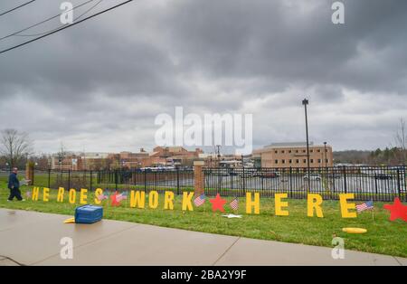 Pennsylvania, Stati Uniti. 25 Marzo 2020. Un uomo non identificato ha messo un segno che ha letto, 'Heroes lavoro qui' un messaggio di speranza Mercoledì, 25 marzo 2020 al Doylestown Hospital in Doylestown, Pennsylvania. Credit: William Thomas Cain/Alamy Live News Foto Stock