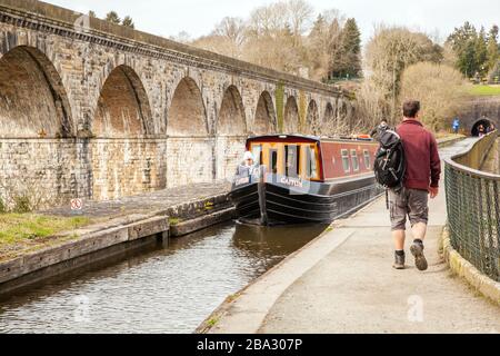 Una barca stretta che passa sopra l'acquedotto costruito da Thomas Telfod a Chirk nel Galles del Nord con il Viadotto della Ferrovia Chirk che corre lungo la Valle di Ceiriog Foto Stock