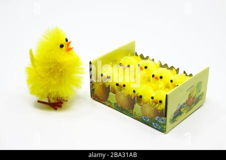 Gruppo di simpatici pulcini pasquali in cartone, cestino di carta Foto Stock