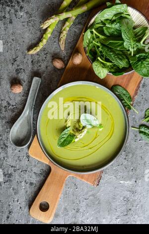 Facile da preparare in un piatto di ceramica asparagi cremosi e zuppa di spinaci Foto Stock