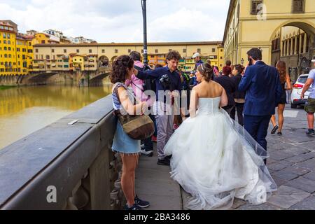 Newlyweds sulla riva nord dell'Arno e Ponte Vecchio, Firenze, Toscana, Italia. Forbes lo classificò come una delle città più belle del mondo Foto Stock