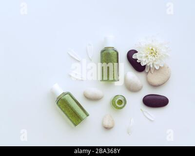 Fiori di Peony, petali floreali, pietre e shampoo o bottiglie di gel doccia isolato su sfondo bianco con spazio copia. Kit relax Spa Foto Stock