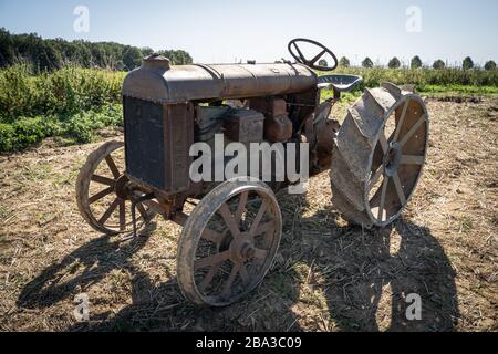Vecchio e antico fordson tractorr lavorando con un aratro nei campi, mostrando come l'agricoltura è stata fatta molti anni fa. Foto Stock