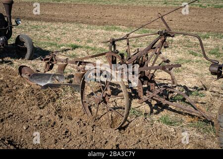 Vecchio e antico fordson tractorr lavorando con un aratro nei campi, mostrando come l'agricoltura è stata fatta molti anni fa. Foto Stock