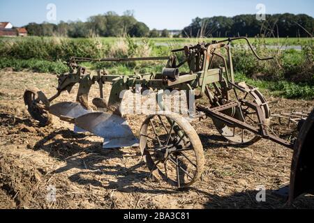 Vecchio e antico fordson tractorr lavorando con un aratro nei campi, mostrando come l'agricoltura è stata fatta molti anni fa. Foto Stock