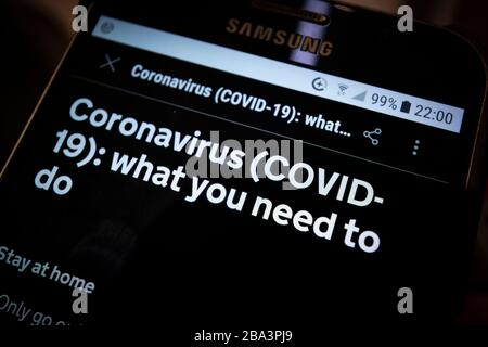 Le istruzioni di blocco del governo viste su un telefono cellulare per rimanere a casa e proteggere il NHS da distanza sociale durante la pandemia di Coronavirus Foto Stock