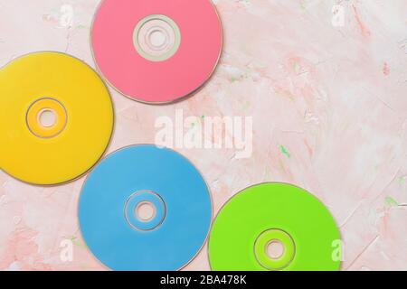 Dischi CD o DVD rossi su rosa. Retro sfondo minimalista, spazio copia Foto Stock