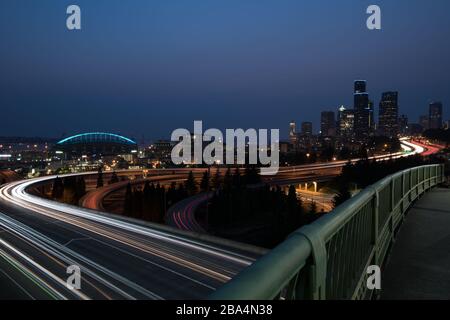 Street scene di Seattle dal Ponte Jose Rizal con sentieri leggeri da auto in movimento. Foto Stock