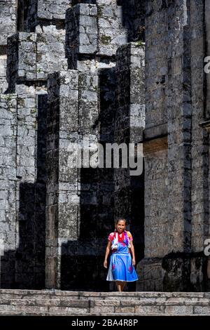 Signora vestita tradizionalmente fuori della cattedrale di pietra a Cuetzalan, Puebla, Messico. Foto Stock