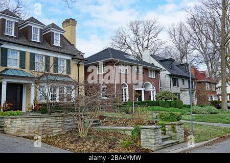 Strada residenziale con grandi case indipendenti con cortili anteriori con alberi maturi Foto Stock