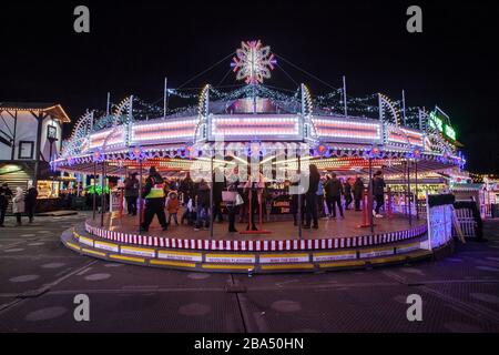 Bar su un round-a-bout o allegro-go-round durante i mercatini di Natale. Decorato in luci Foto Stock