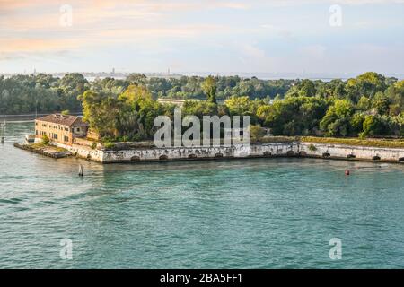 Il sole inizia a tramontare su Forte Sant'Andrea, sull'isola di le Vignole, nelle acque al largo di Venezia. Foto Stock