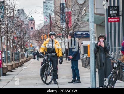 TORONTO, CANADA - 01 04 2020: Poliziotto della polizia di Toronto che parla con un uomo sul viale dell'università nel centro di Toronto Foto Stock