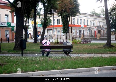 Due donne sedute su una panchina in un piccolo parco polacco nel centro della città. Tomaszow Mazowiecki Polonia centrale Foto Stock