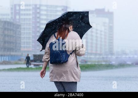 San Pietroburgo, Russia Giugno 2019-murino district, heavy rain, inondazioni, la gente a piedi sotto la pioggia con ombrelloni. Foto Stock