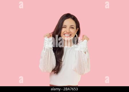 Giovane donna in una blusa bianca che guarda felice Foto Stock