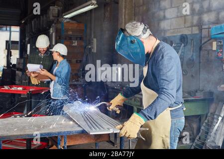 Saldatore come lavoratore saldante acciaio in una fabbrica di metallo Foto Stock