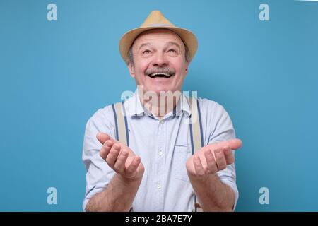 felice uomo anziano nel cappello estivo che chiede misericordia di dio Foto Stock