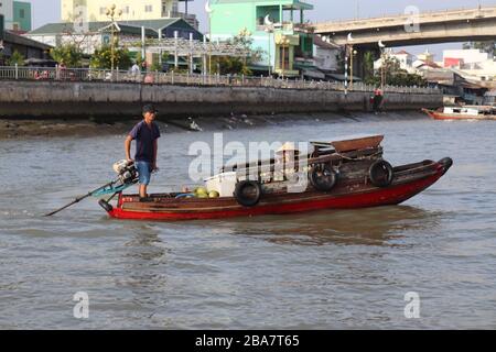 PERSONE VIETNAMITE CHE TRASPORTANO E COMMERCIANO MERCI SUL FIUME MEKONG NEL DELTA, VIETNAM. Foto Stock