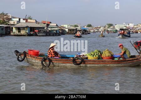 PERSONE VIETNAMITE CHE TRASPORTANO E COMMERCIANO MERCI SUL FIUME MEKONG NEL DELTA, VIETNAM. Foto Stock