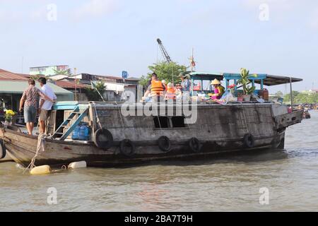 PERSONE VIETNAMITE CHE TRASPORTANO E COMMERCIANO MERCI SUL FIUME MEKONG NEL DELTA, VIETNAM. Foto Stock