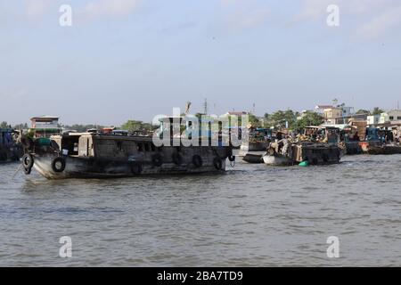 PERSONE VIETNAMITE CHE TRASPORTANO E COMMERCIANO MERCI SUL FIUME MEKONG NEL DELTA, VIETNAM. Foto Stock