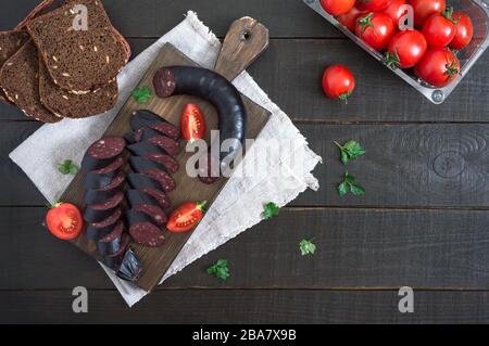 Morsilla - salsiccia di sangue. Pezzi di budino nero spagnolo su un tagliere di legno. Menu di Pasqua. La vista dall'alto Foto Stock