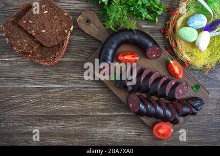 Morsilla - salsiccia di sangue. Pezzi di budino nero spagnolo su un tagliere di legno. Menu di Pasqua. La vista dall'alto Foto Stock