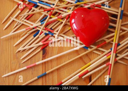 Gioco di bastone di legno con un cuore rosso su un tavolo di legno. CONCETTO DI AMORE, concetto DI GIOCO Foto Stock