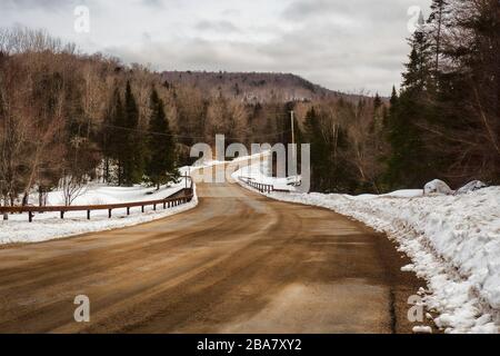 Sabbia coperta Adirondak montagna backwoods strada in inverno Foto Stock