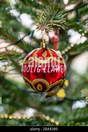 casa dipinta a mano gallese albero di natale decorazione bauble raffigurante Nadolig Llawen, tradotto come buon Natale in lingua gallese Foto Stock