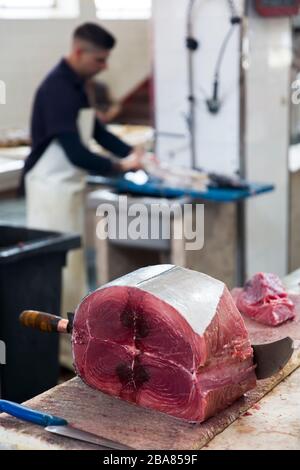 FUNCHAL, PORTOGALLO - 15 FEBBRAIO 2020: Uomo non identificato che taglia il tonno Mercado dos Lavradores (mercato agricolo) a Funchal all'Isola di Madeira, Portogallo. M Foto Stock