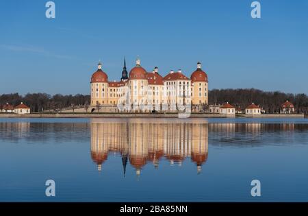 Moritzburg, Germania. 23 marzo 2020. Il Castello di Moritzburg, l'ex rifugio di caccia della famiglia Wettin, si riflette nello stagno del castello al mattino. Credit: Robert Michael/dpa-Zentralbild/dpa/Alamy Live News Foto Stock