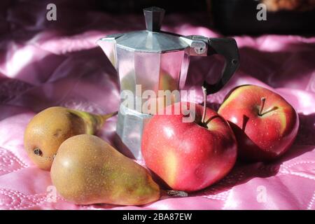 caffè del mattino in pentola con mele e pere a tavola Foto Stock