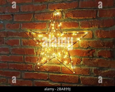 Stella gialla brillante su un muro di mattoni Foto Stock