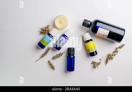 Bottiglie di oli essenziali di aromaterapia, candele e semi secchi di lavanda Foto Stock