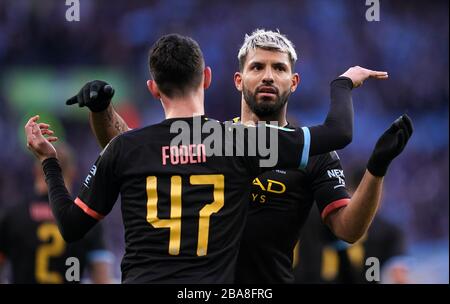 Sergio Aguero (a destra) di Manchester City festeggia il primo goal del suo fianco con il compagno di squadra Phil Foden. Foto Stock