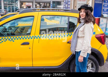 Bella ragazza giovane apre o chiude la porta di un taxi giallo con il suo concetto di stile di vita donna hand.Traveler. Foto Stock