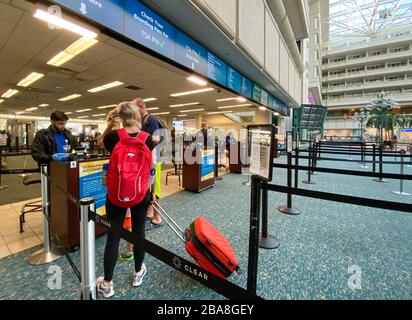 Orlando,FL/USA-3/21/20: Persone che attraversano l'Aeroporto Internazionale di Orlando MCO TSA sicurezza in maschere in un giorno lento a causa del coronavirus. Foto Stock