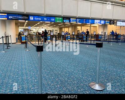 Orlando, FL/USA-3/21/20: Persone che attraversano l'Aeroporto Internazionale di Orlando MCO TSA sicurezza in una giornata lenta a causa del coronavirus. Foto Stock