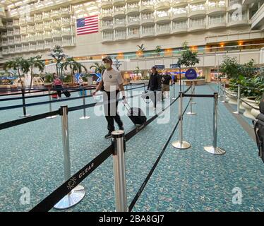 Orlando,FL/USA-3/21/20: Persone che attraversano l'Aeroporto Internazionale di Orlando MCO TSA sicurezza in maschere in un giorno lento a causa del coronavirus. Foto Stock