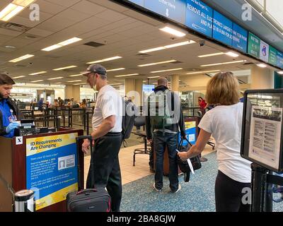 Orlando,FL/USA-3/21/20: Persone che attraversano l'Aeroporto Internazionale di Orlando MCO TSA sicurezza in maschere in un giorno lento a causa del coronavirus. Foto Stock