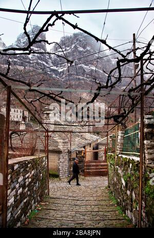 Uomo solitario a piedi in Mikro Papigo, uno dei più bei villaggi montani greci, Zagori regione, Ioannina, Epiro. Foto Stock