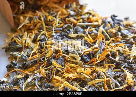 Tisana closeup. Foglie di tè alle erbe multicolori e sacchetto di carta kraft marrone con messa a fuoco selettiva. Foto Stock