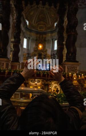 Il turista fotografa all'interno della Basilica di San Pietro in Vaticano Foto Stock
