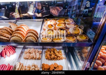Pasticcini assortiti e altri piatti caldi in vendita presso uno stand Hawker, Bugis, Singapore Foto Stock
