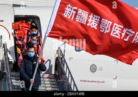 Urumqi, la regione autonoma cinese di Xinjiang Uygur. 26 marzo 2020. I membri del team medico scatteranno da un aereo dopo essere arrivati all'Aeroporto Internazionale di Diwopu a Urumqi, nella regione autonoma di Xinjiang Uygur, nel nord-ovest della Cina, il 26 marzo 2020. Un totale di 142 medici sono tornati a Xinjiang giovedì dopo aver aiutato la lotta contro il COVID-19 nella provincia di Hubei della Cina centrale. Credit: Wang Fei/Xinhua/Alamy Live News Foto Stock