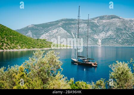 Vacanze estive in Grecia. Lussuoso yacht privato nero all'ancora nella splendida laguna di mare. Isola di Ithaka. Foto Stock