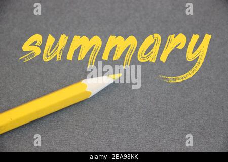 Sommario parola mano scritta in lettere gialle con matita oltre su sfondo grigio. Business photo Brief Statement Abstract Synopsis conciso concetto Foto Stock